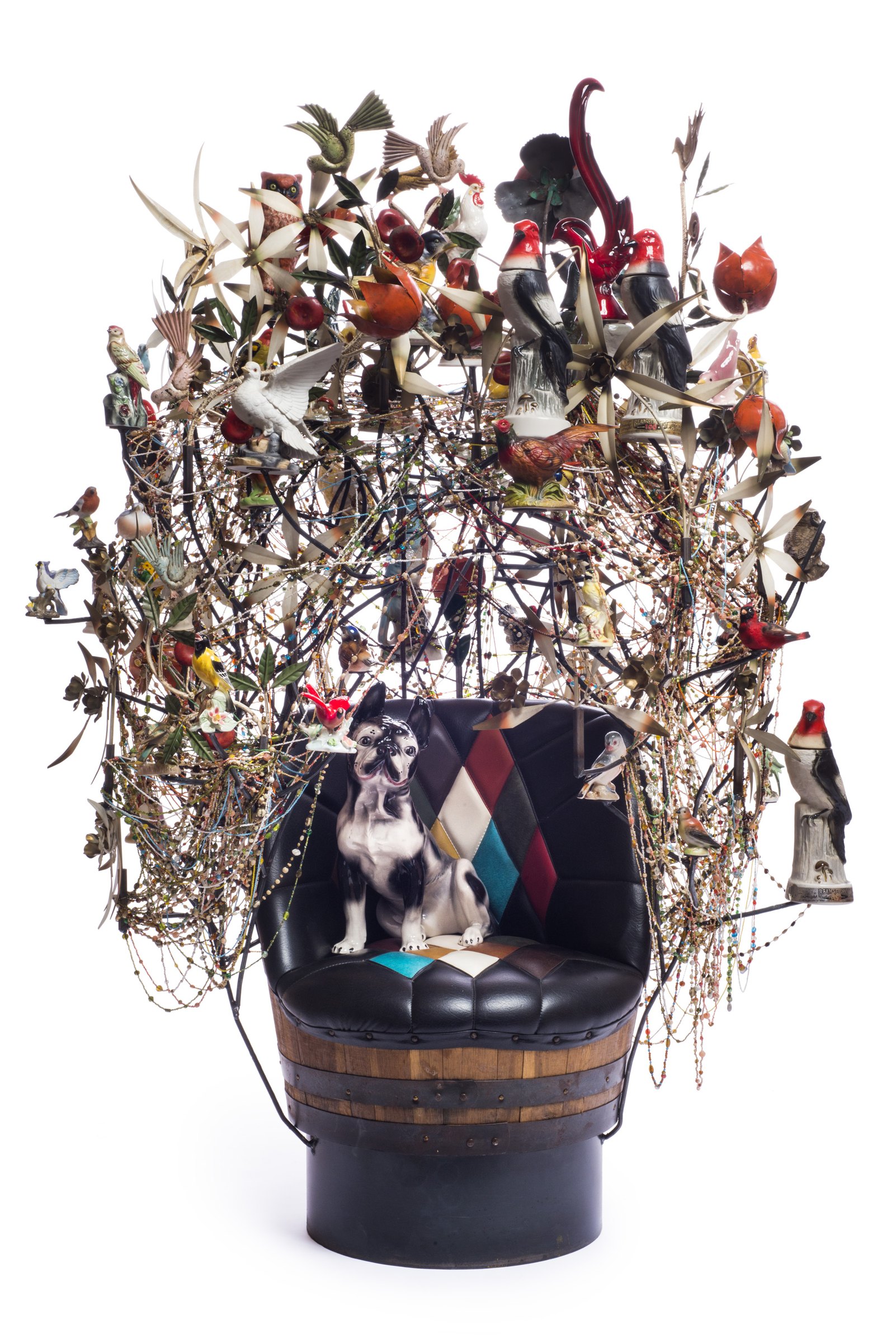 Nick Cave, Rescue: a sculpture of a seated dog figure beneath a tall tree of found metal flowers and birds