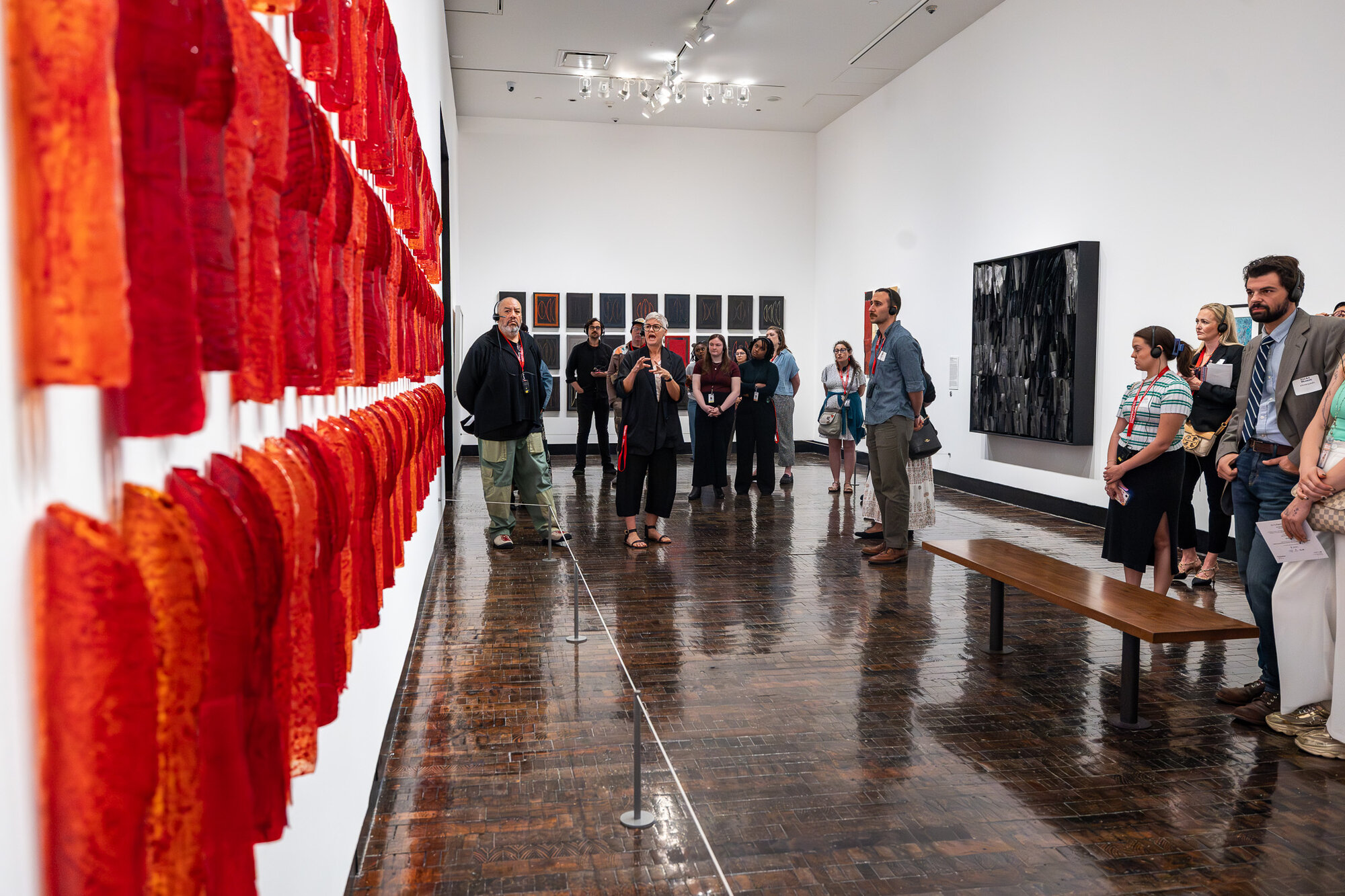 Visitors viewing a red textile installation in "An Indigenous Present" at the Frist Art Museum