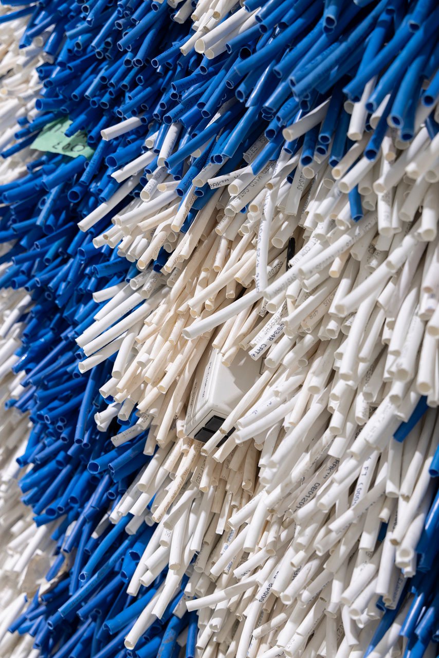 Detail of Emily Hermant’s Pile It On, showing blue and white ethernet jackets