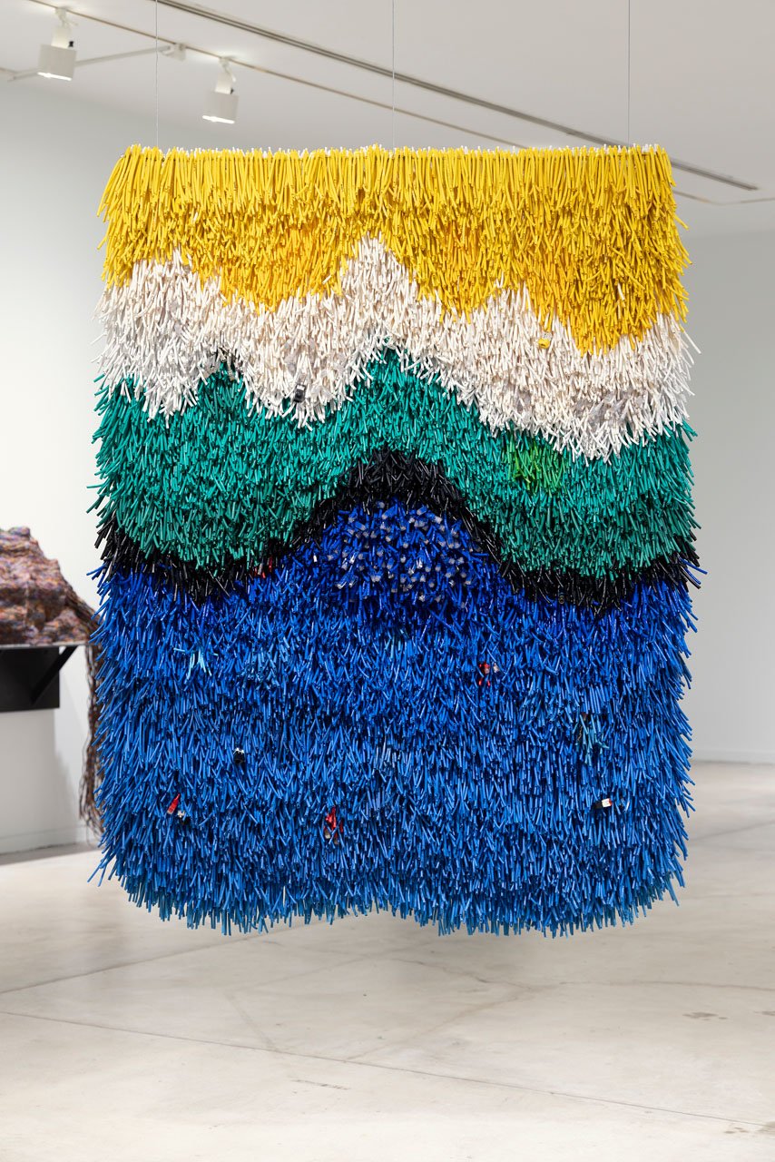 Emily Hermant’s Talk Through Me, a hanging work of stripped cables in bands of yellow, white, green and blue