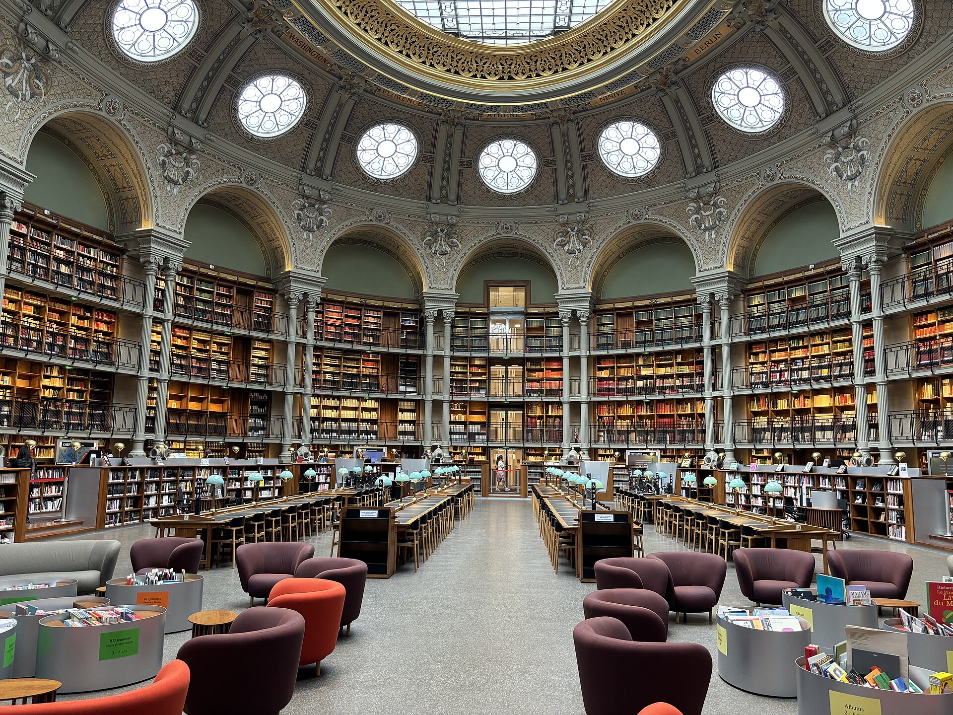 The Salle Ovale reading room at the BnF Richelieu site in Paris, its glazed oval dome above tiers of bookshelves.