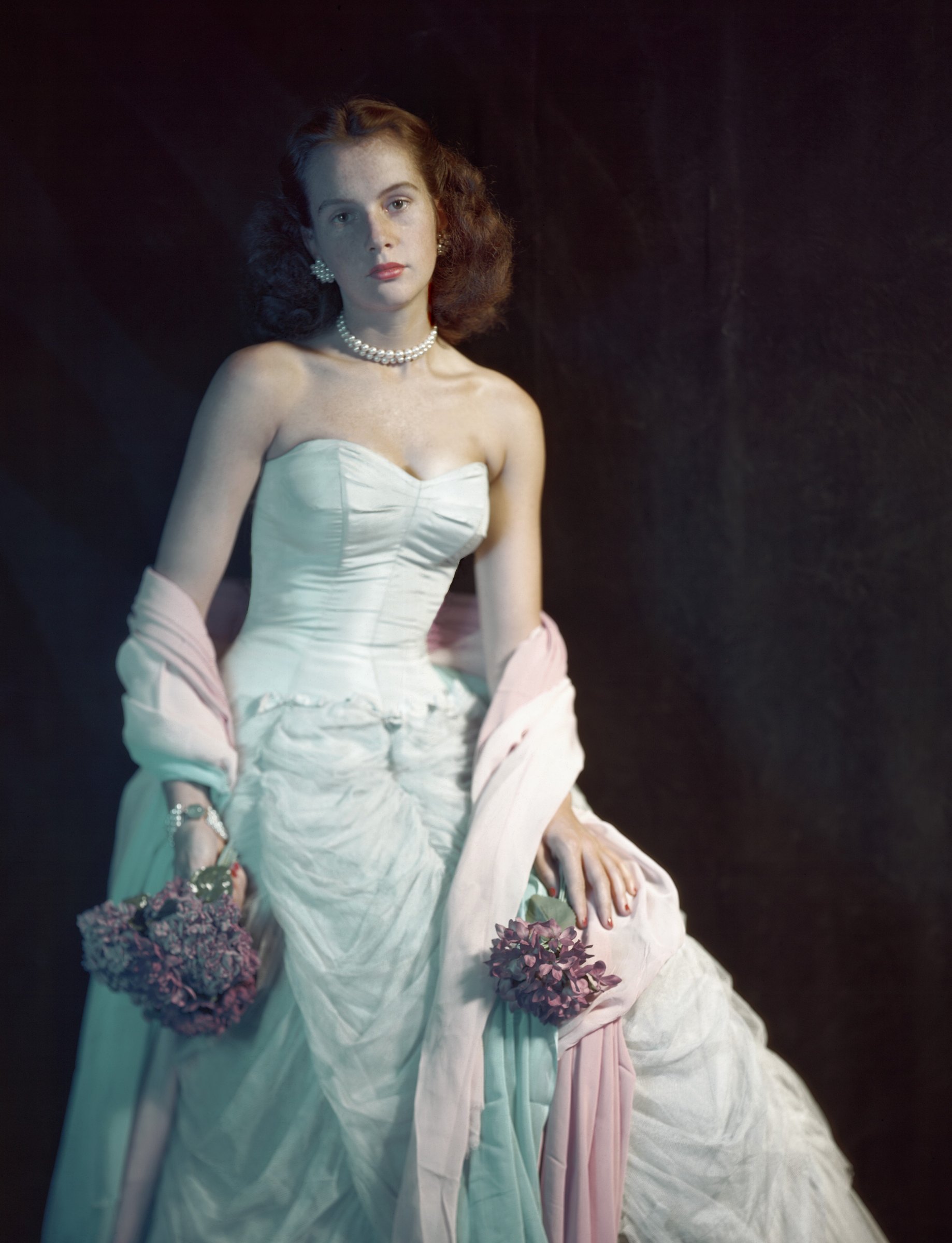 Cecil Beaton, Nancy Harris at the Coty Ball: a young woman in a pale strapless ballgown and pink stole holding a small bouquet