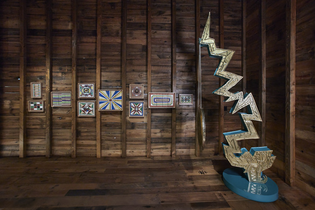 Art Preserve view with a zigzag lightning sculpture before a wood wall of small Blagdon panels
