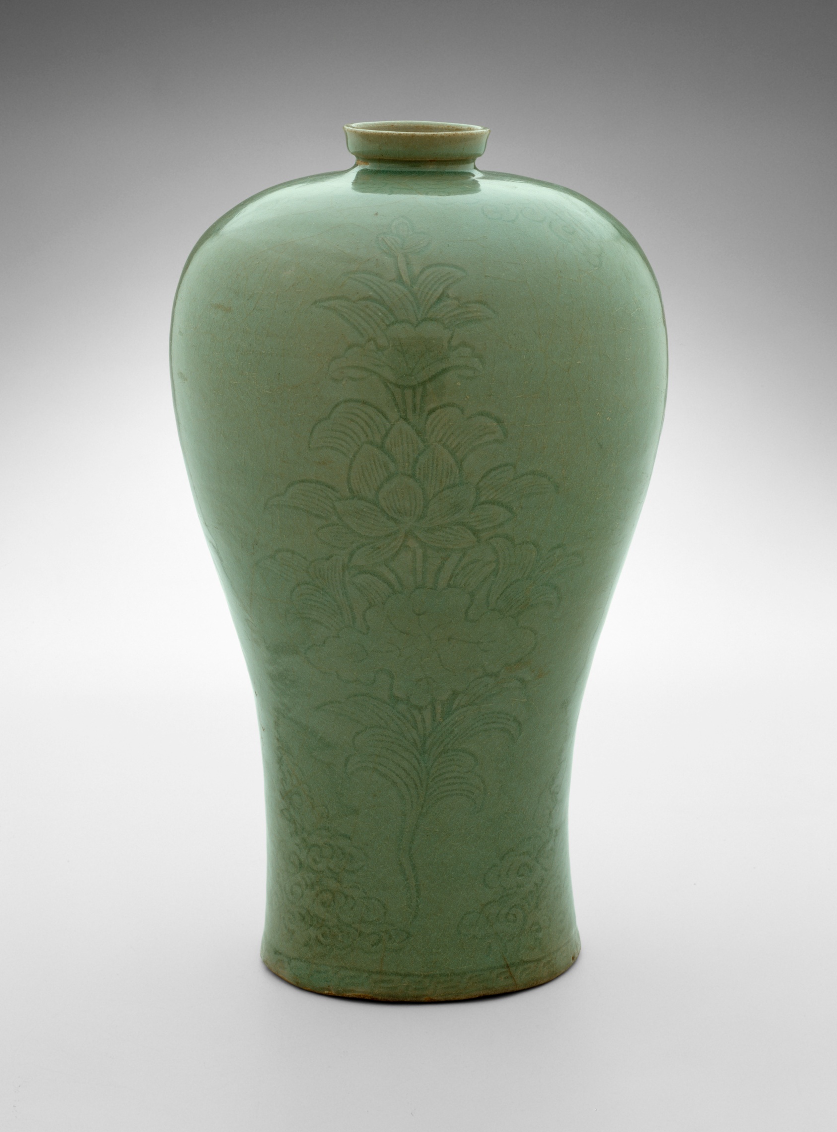 A Goryeo celadon plum vase with a broad shoulder tapering to a narrow foot, covered in a soft grey-green glaze and incised with a large lotus spray.