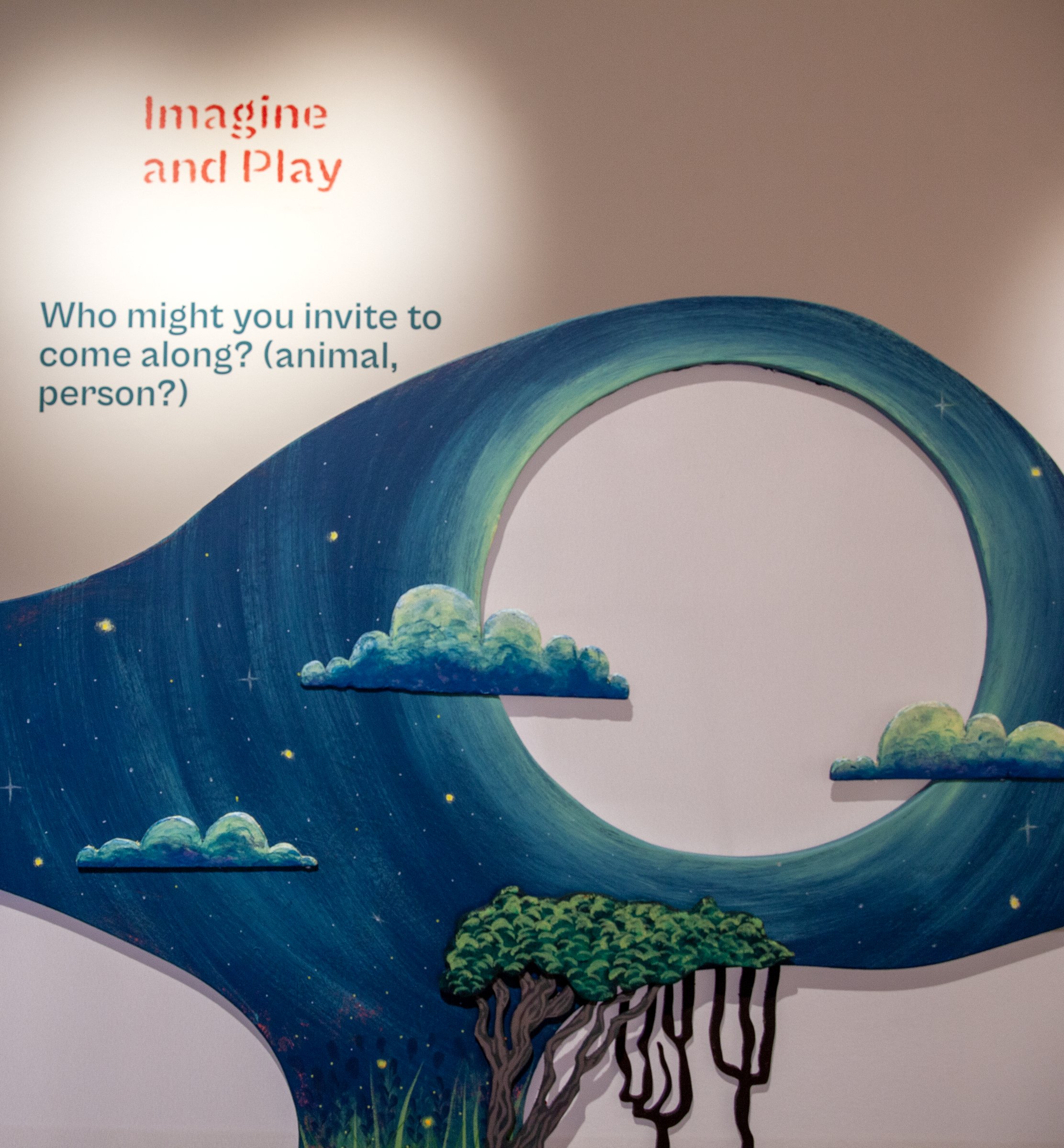 Forever Play gallery wall with the words Imagine and Play and a blue wave-shaped cutout