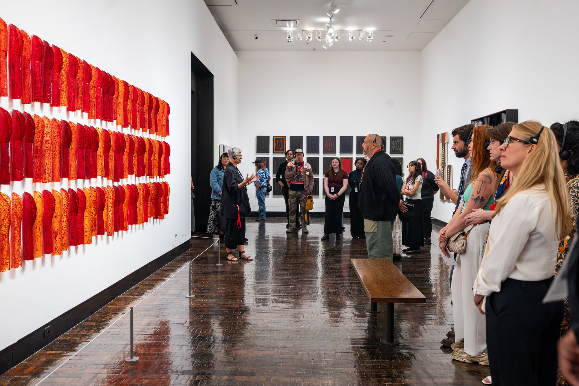 Gallery view of red textile installation with visitors in "An Indigenous Present" at the Frist Art Museum