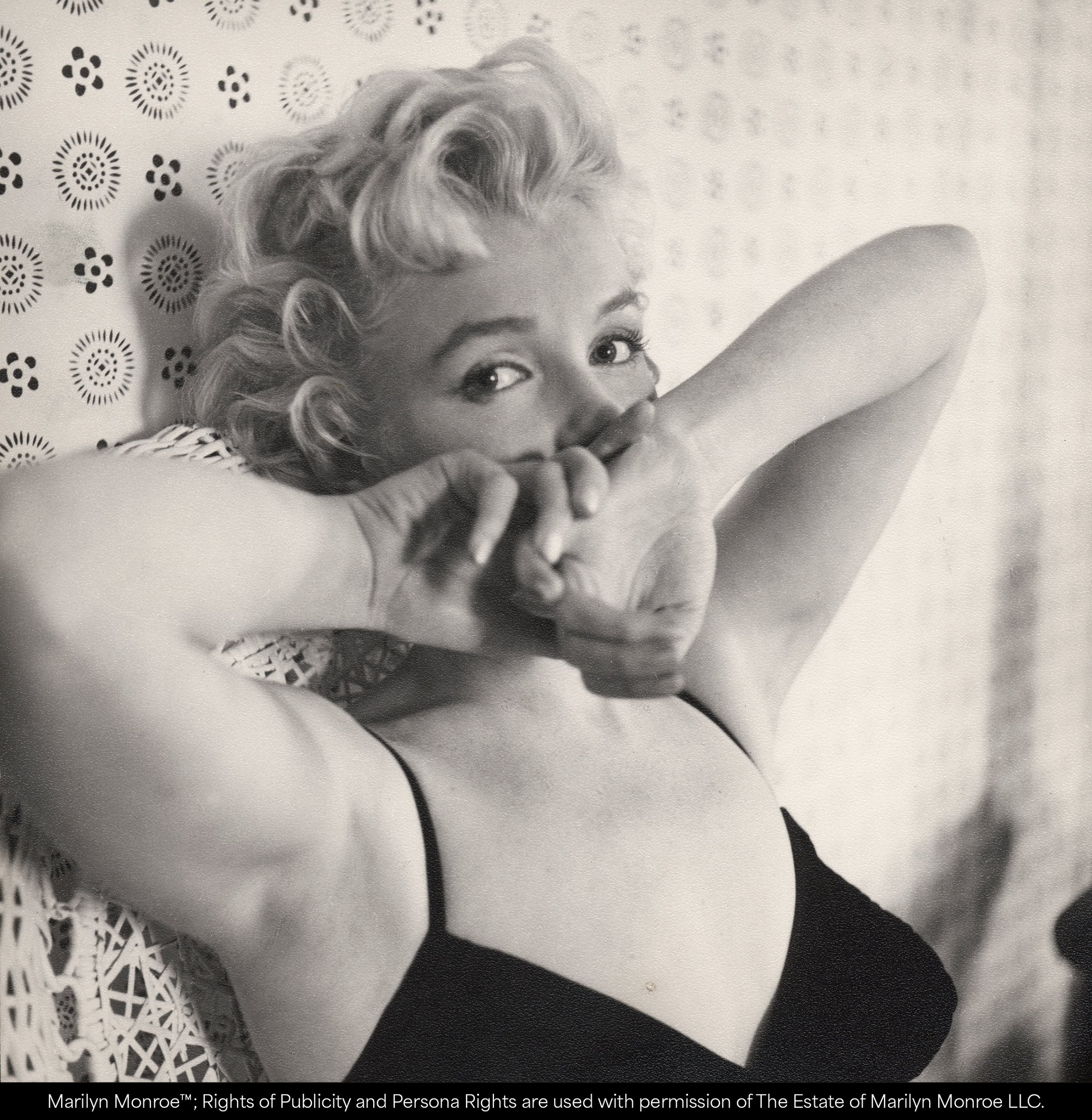 Cecil Beaton, The Wonder of the Age: Marilyn Monroe lying back with her hands raised to her face against a patterned backdrop