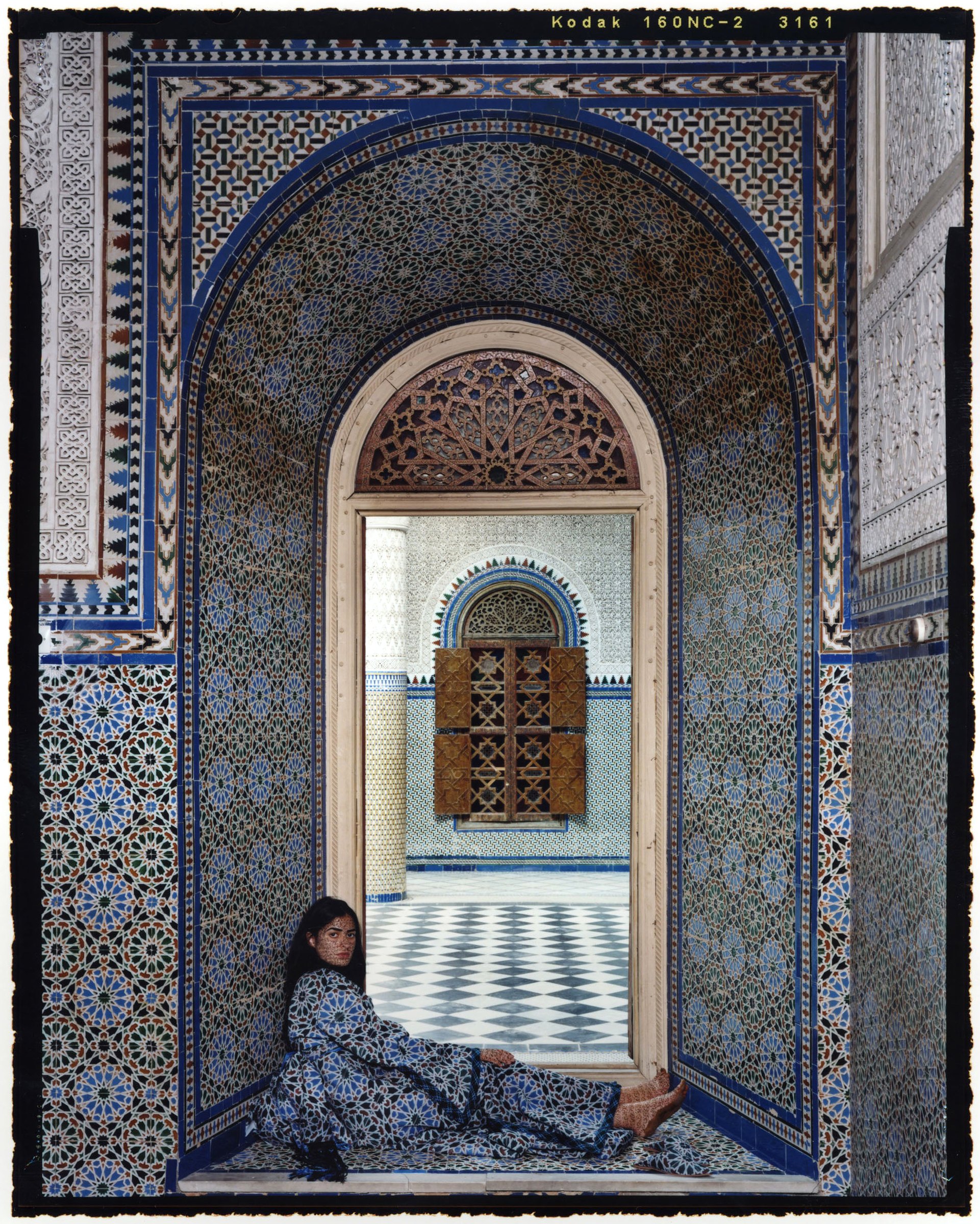 Lalla Essaydi, Harem #14C: a woman reclining in a tiled archway of a Moroccan interior