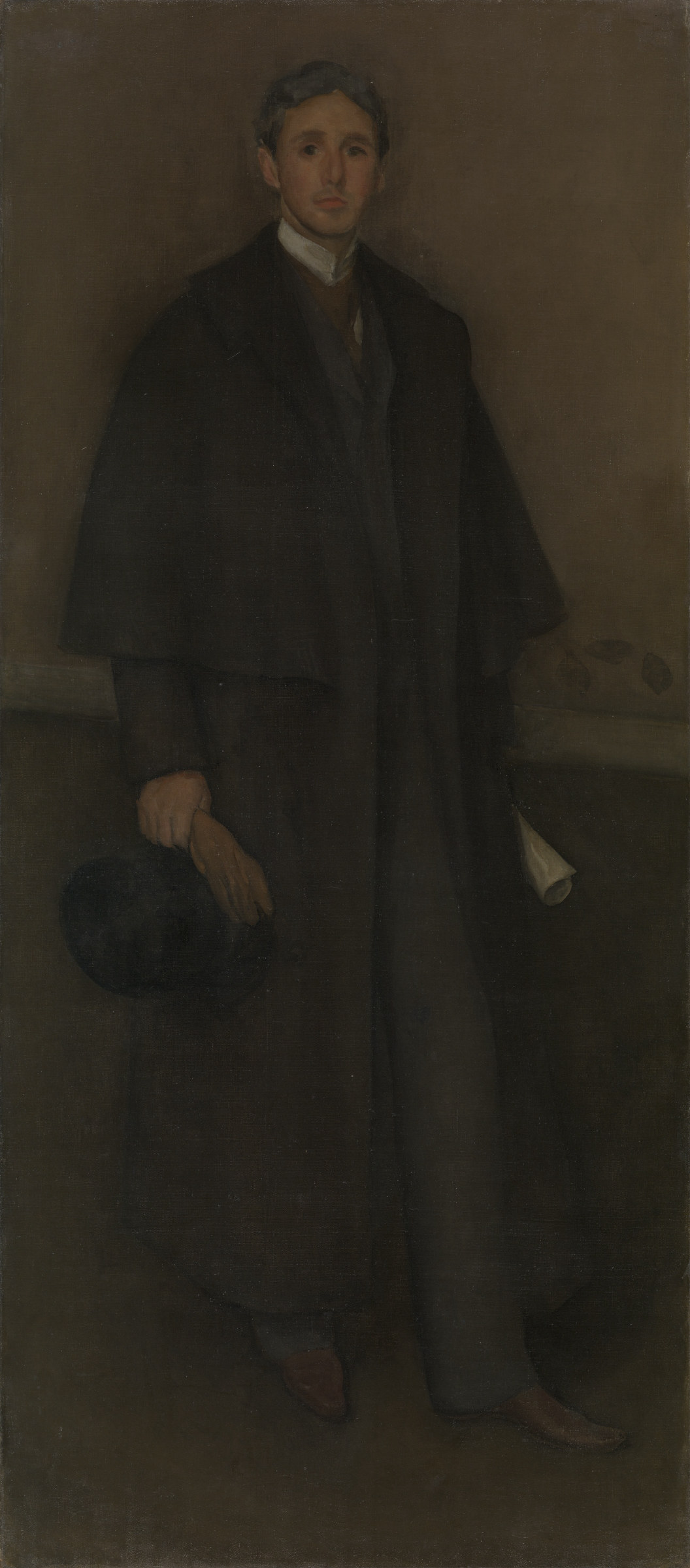 A full-length standing portrait of a man in a long dark coat, set against an almost black ground, with only his face and one hand catching the light.