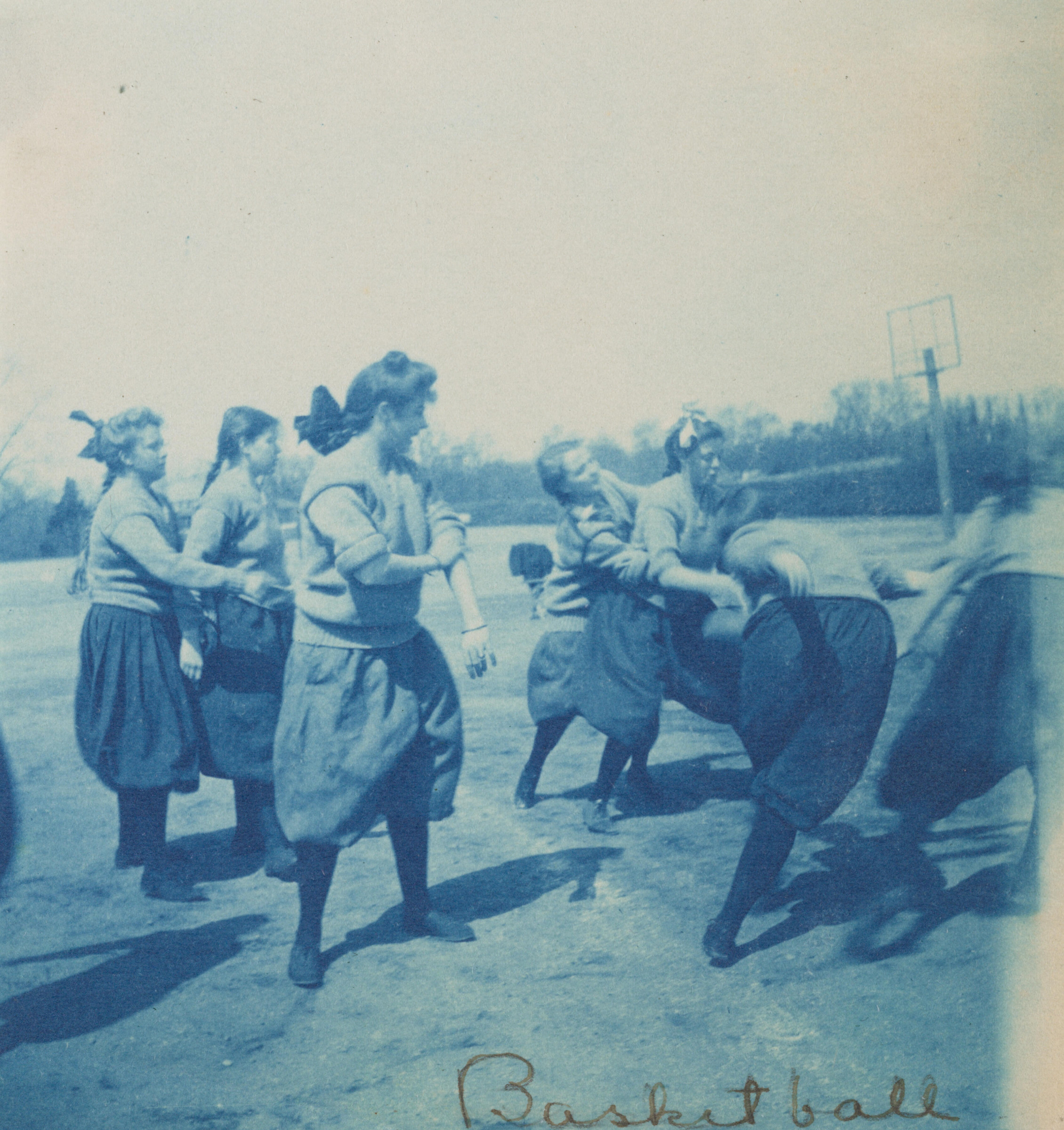 Untitled (Basketball): a cyan-toned photograph of young women in bloomers playing basketball outdoors
