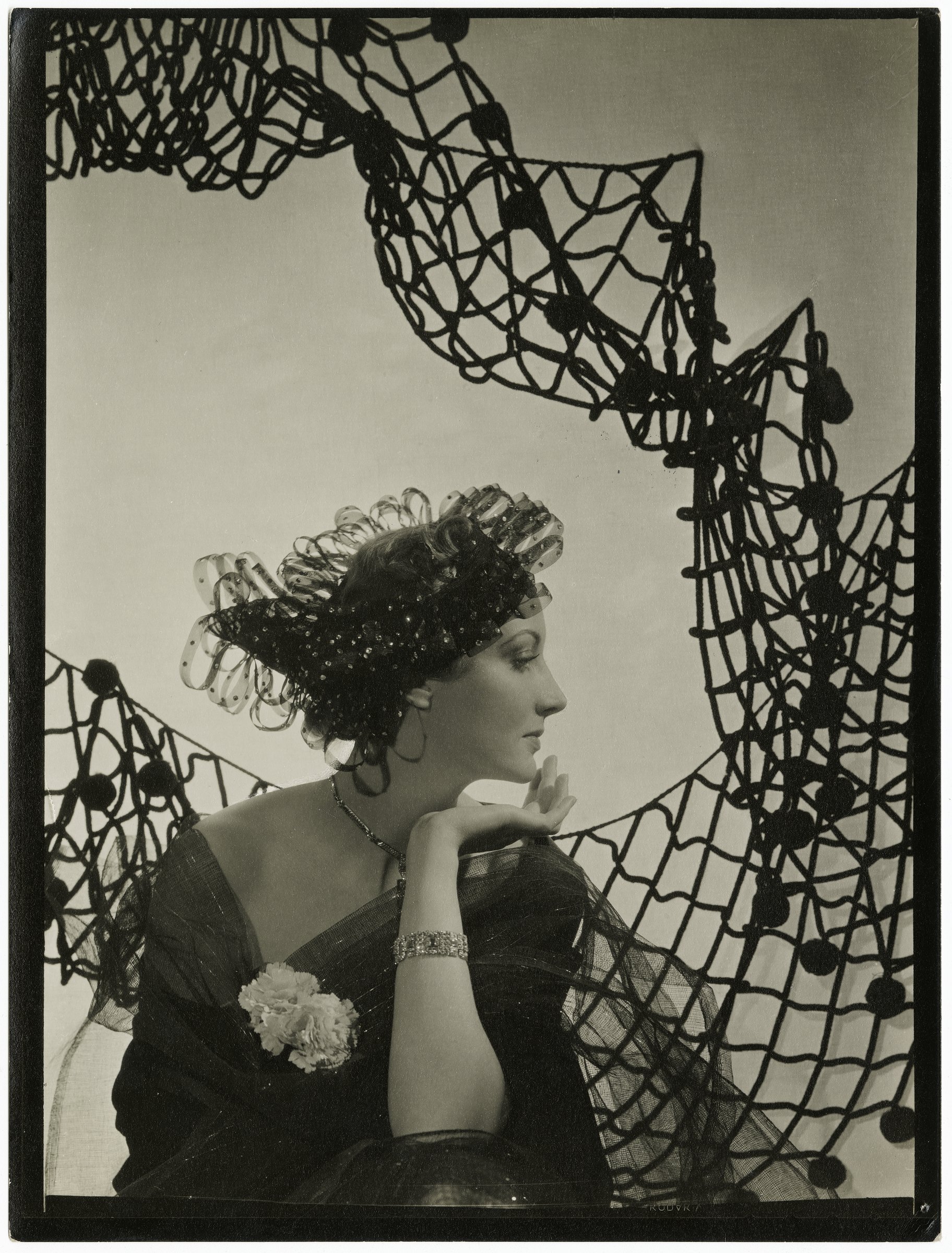 Cecil Beaton, The Paris Collections (Comtesse de la Falaise): a woman in black seated before a draped net