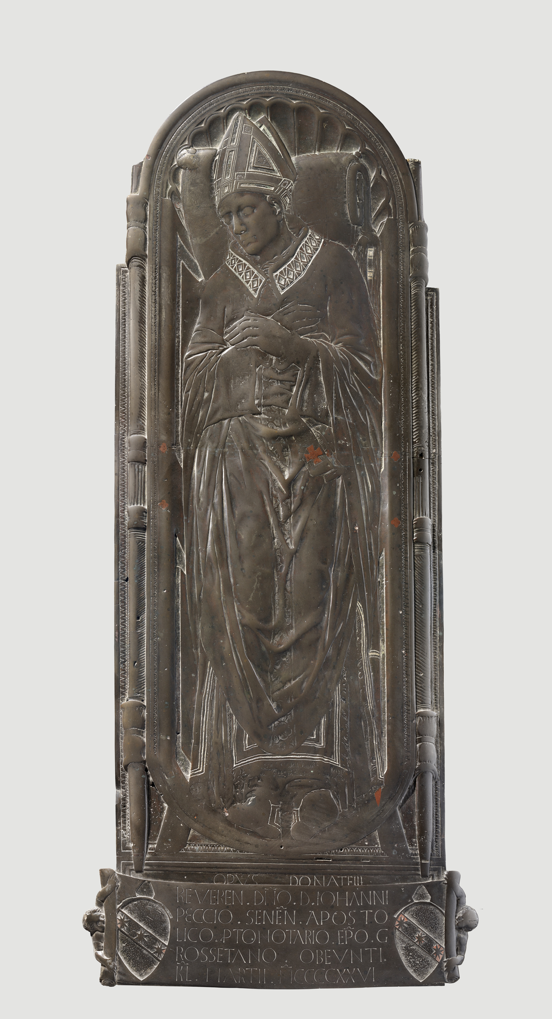 A large bronze tomb slab showing a bishop lying in state in full vestments, hands crossed, seen from above.