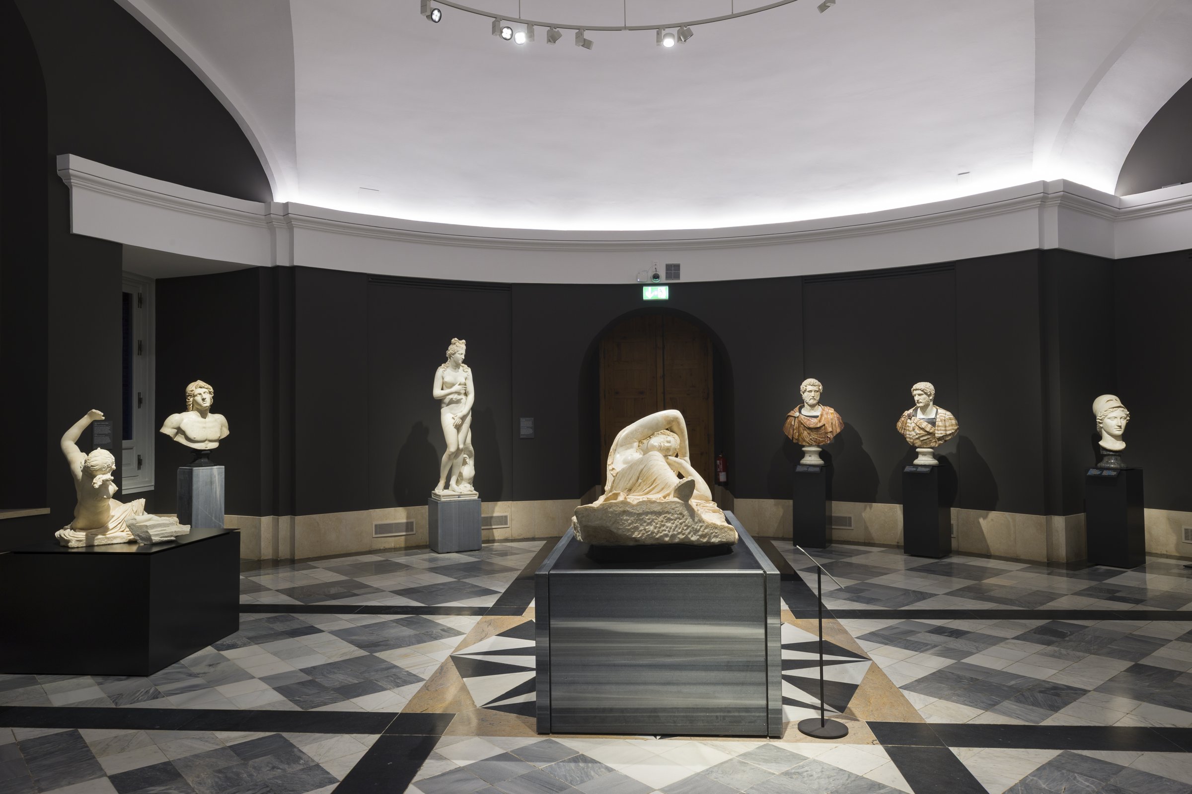 Room 74 at the Museo del Prado, classical sculptures on plinths around a chequered marble floor