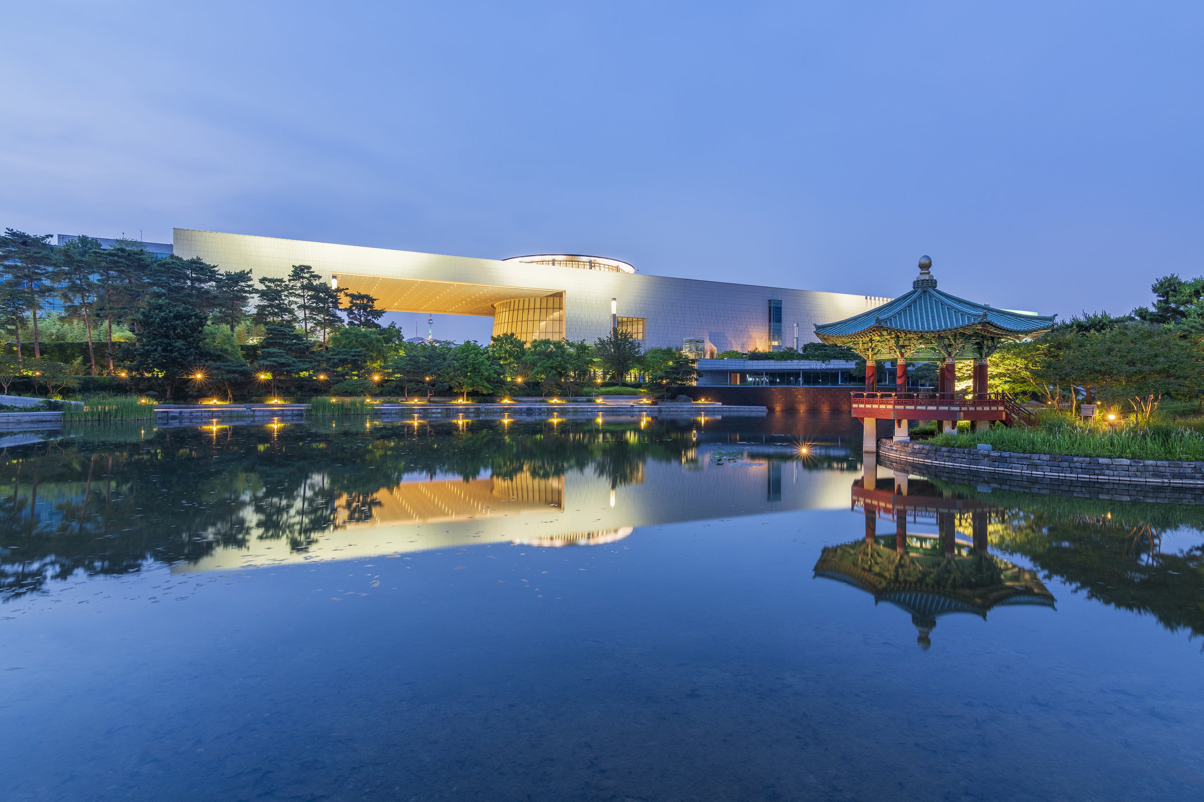 National Museum of Korea at dusk, the long building and a traditional pavilion reflected in the Mirror Pond