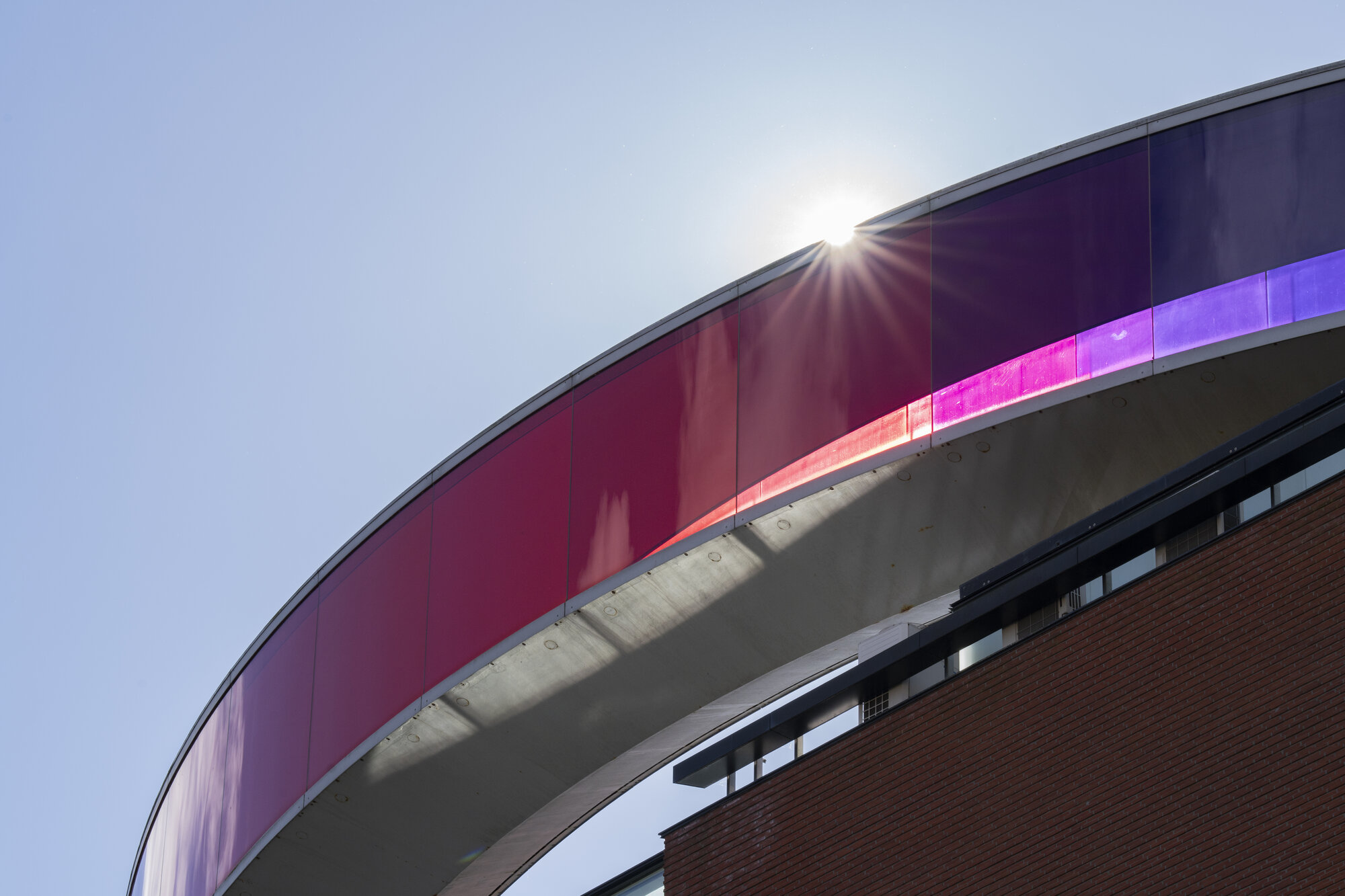 Close view of the Rainbow Panorama rooftop walkway at ARoS Aarhus Kunstmuseum against a blue sky