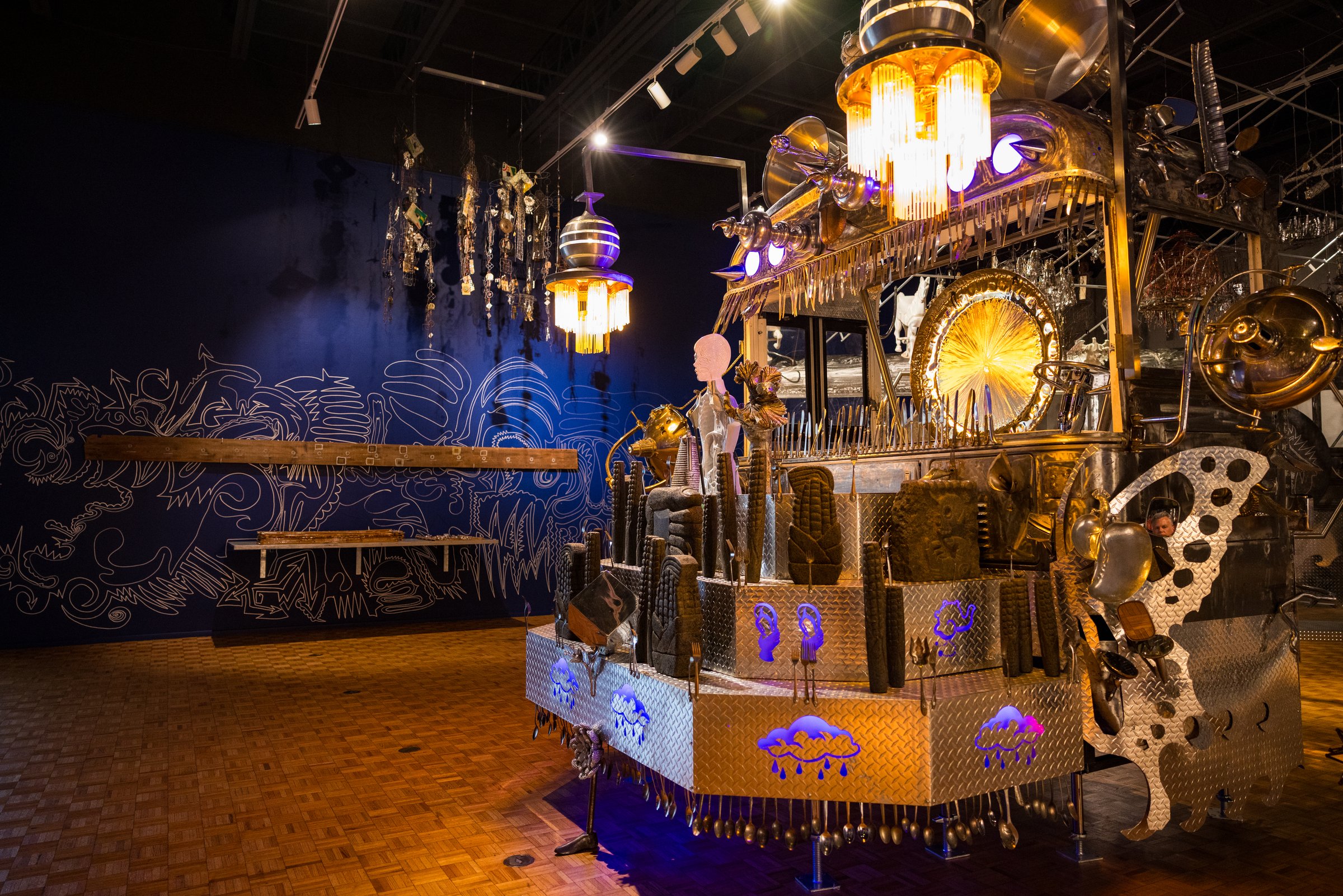 Guadalupe Maravilla’s illuminated sculptural instrument with a butterfly wing in a dark blue gallery