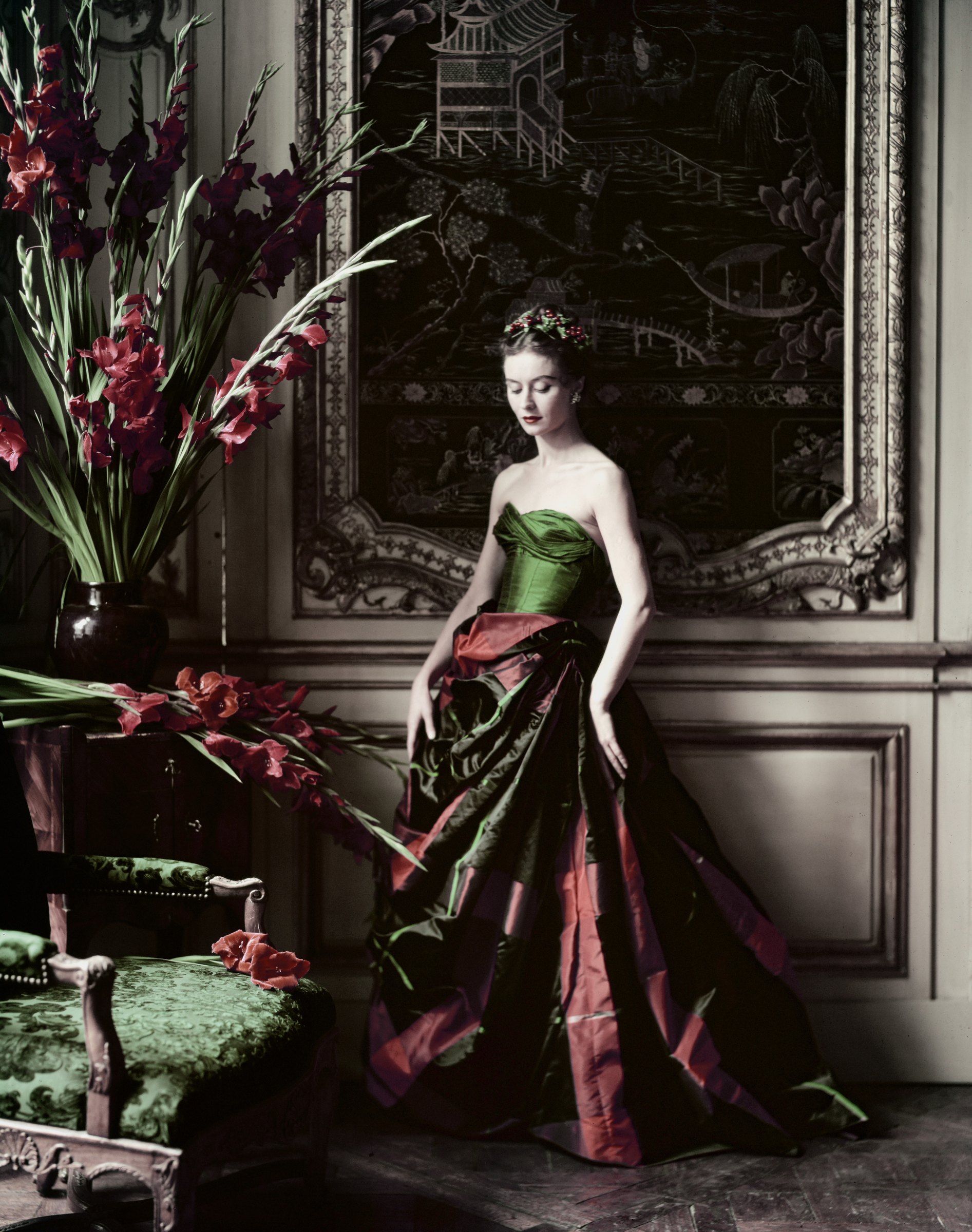 Cecil Beaton, Best Invitation of the Season: a woman in a sweeping green and red ballgown by Balmain standing in a grand paneled room