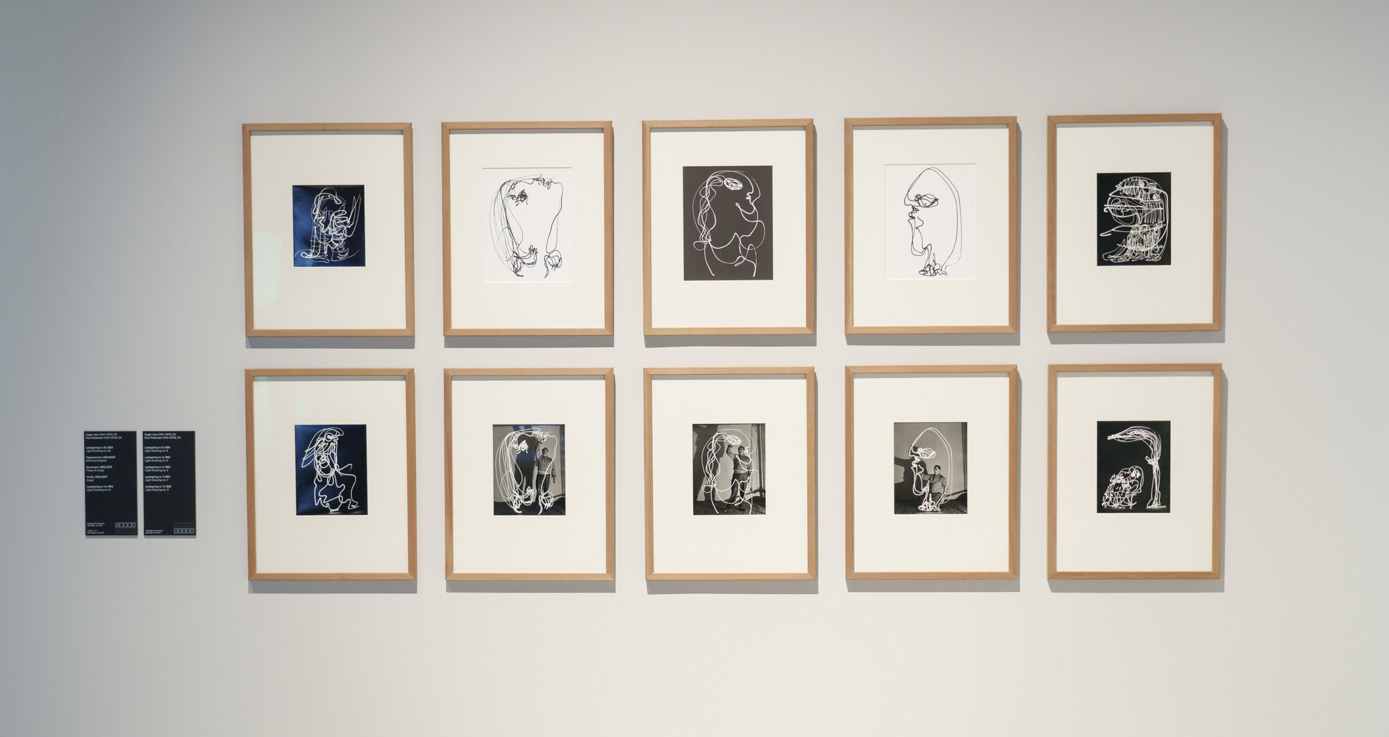 Wall of framed line drawings from the ARoS collection, ten works in light wood frames arranged in two rows