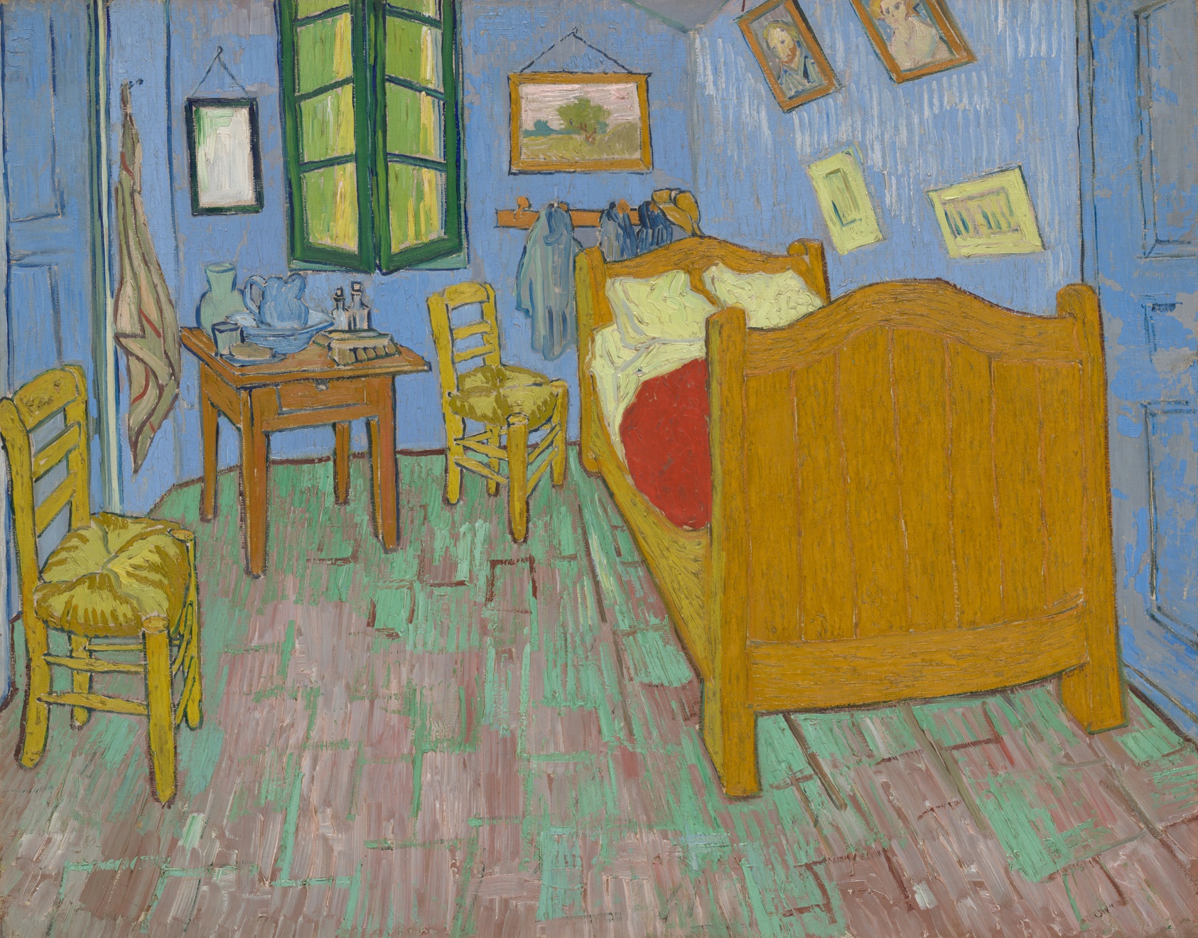 A small bedroom painted in flat planes of blue, yellow and red: a wooden bed against the right wall, two chairs, a window with green shutters, and framed pictures hung above the bed.