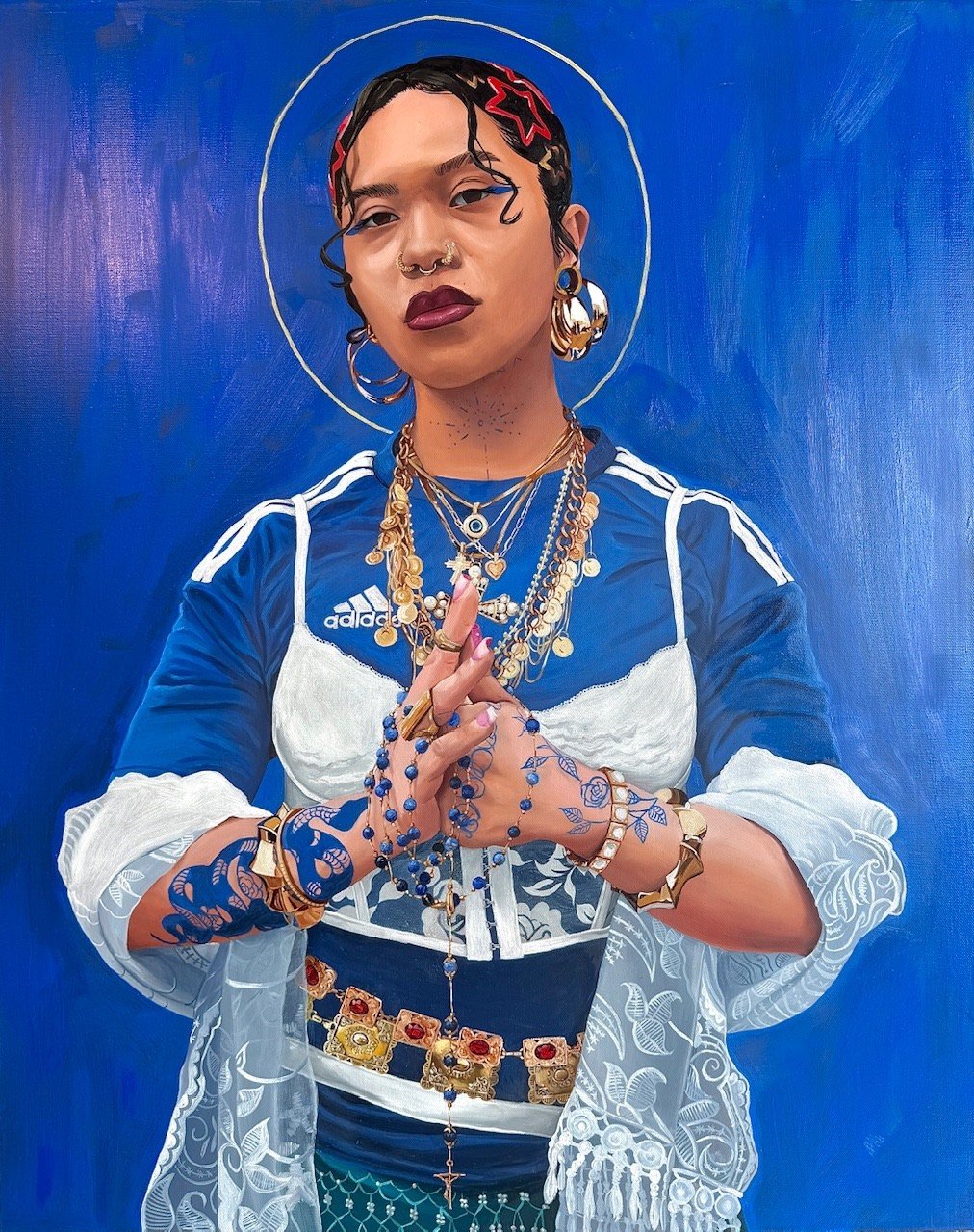 Portrait of a young woman in a blue and white top with hands pressed together against a blue ground