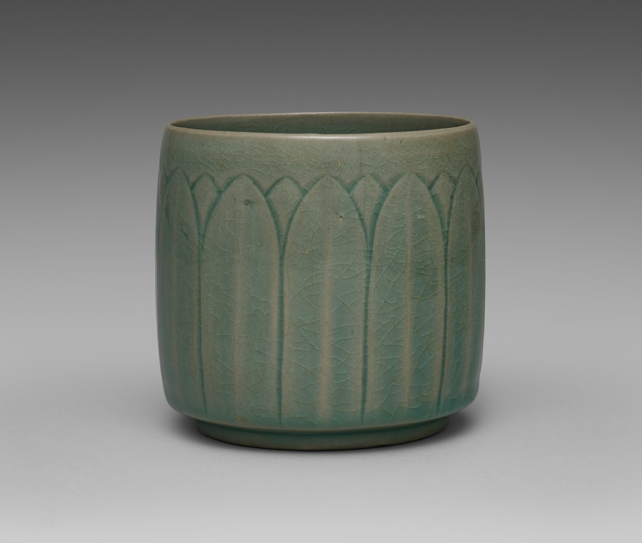 Pale green celadon cup with molded lotus petals around its sides
