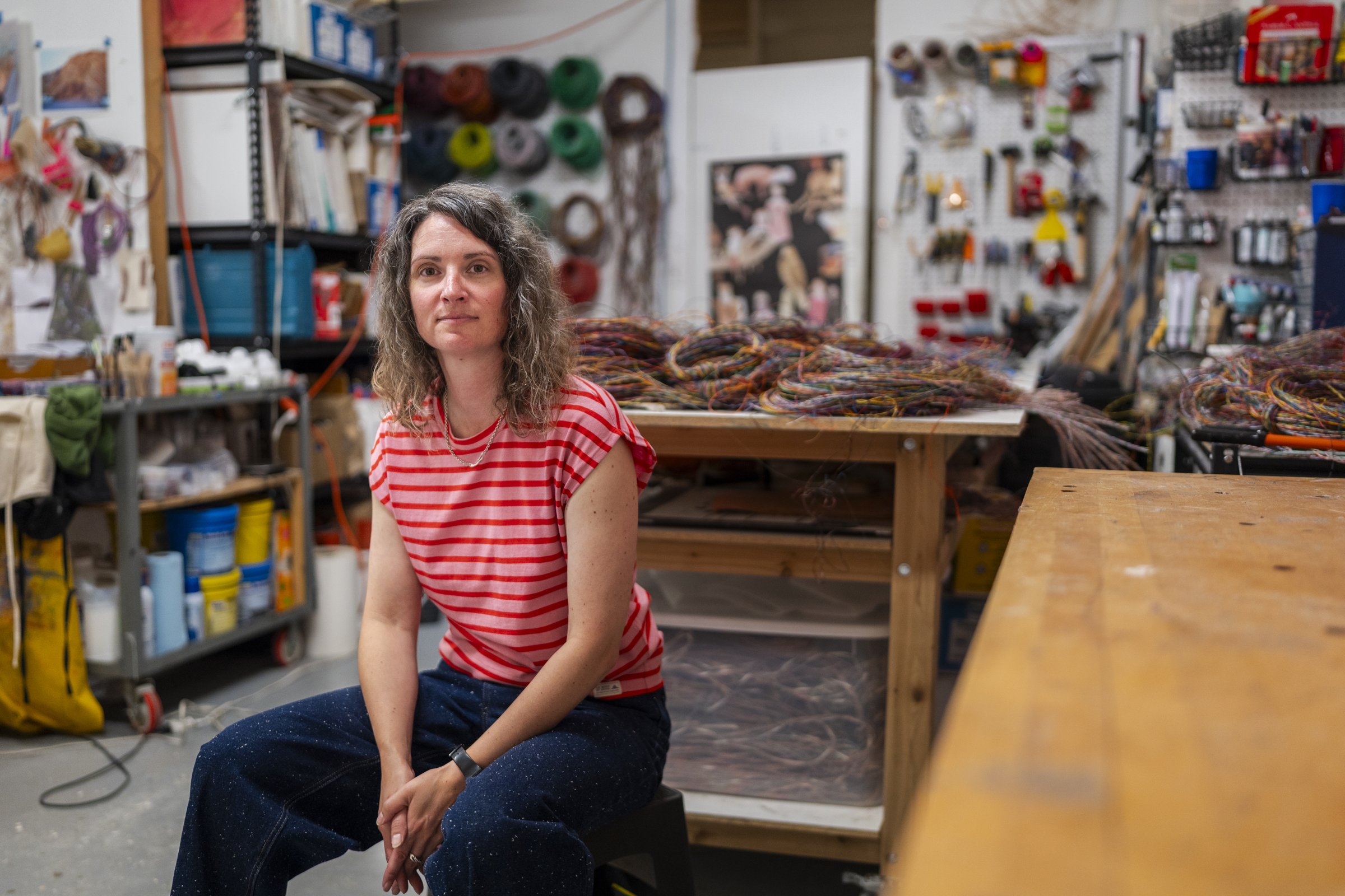Emily Hermant seated in her Vancouver studio among coils of cable